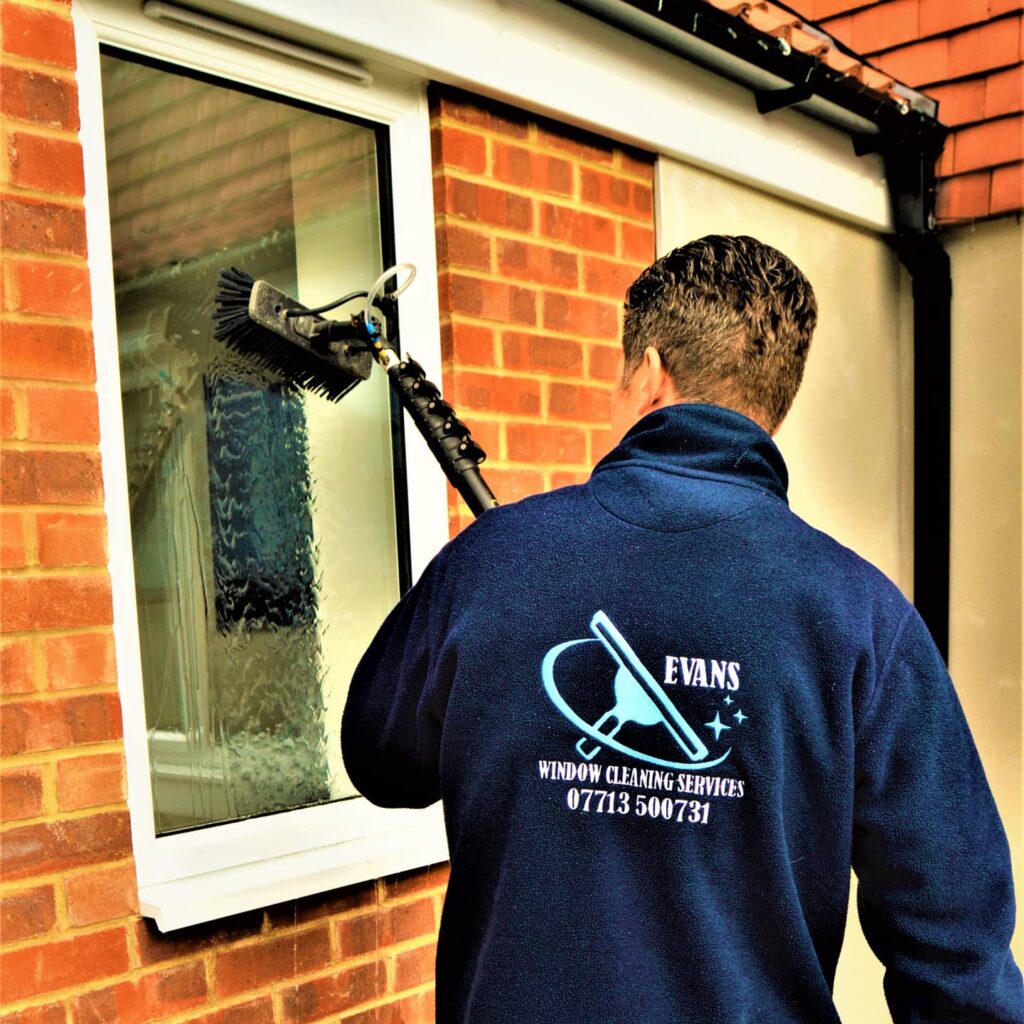EVANS CLEANING SERVICES CLEANING A WINDOW WITH BRUSH